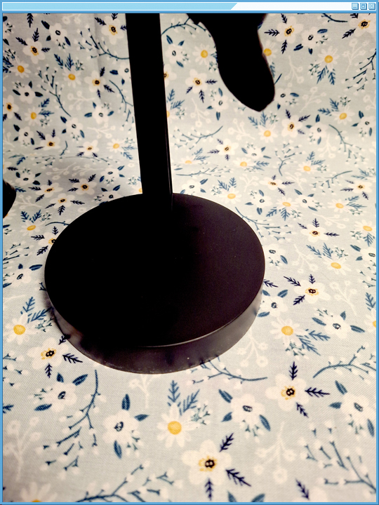 Black circular base with a support rod.